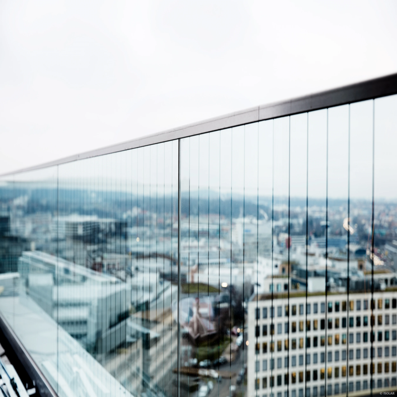 Nahaufnahme einer Glasfassade mit dezenten, vertikalen Linienmustern von ORNILUX, die für Vögel sichtbar sind, aber die Durchsicht für Menschen kaum stören.